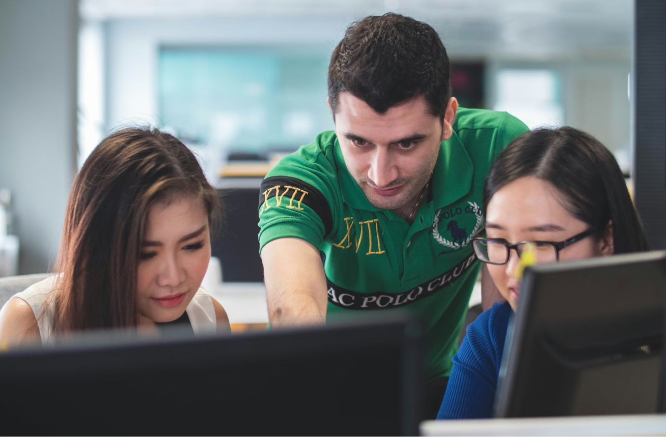 Three students work together on iClicker questions in a computer lab